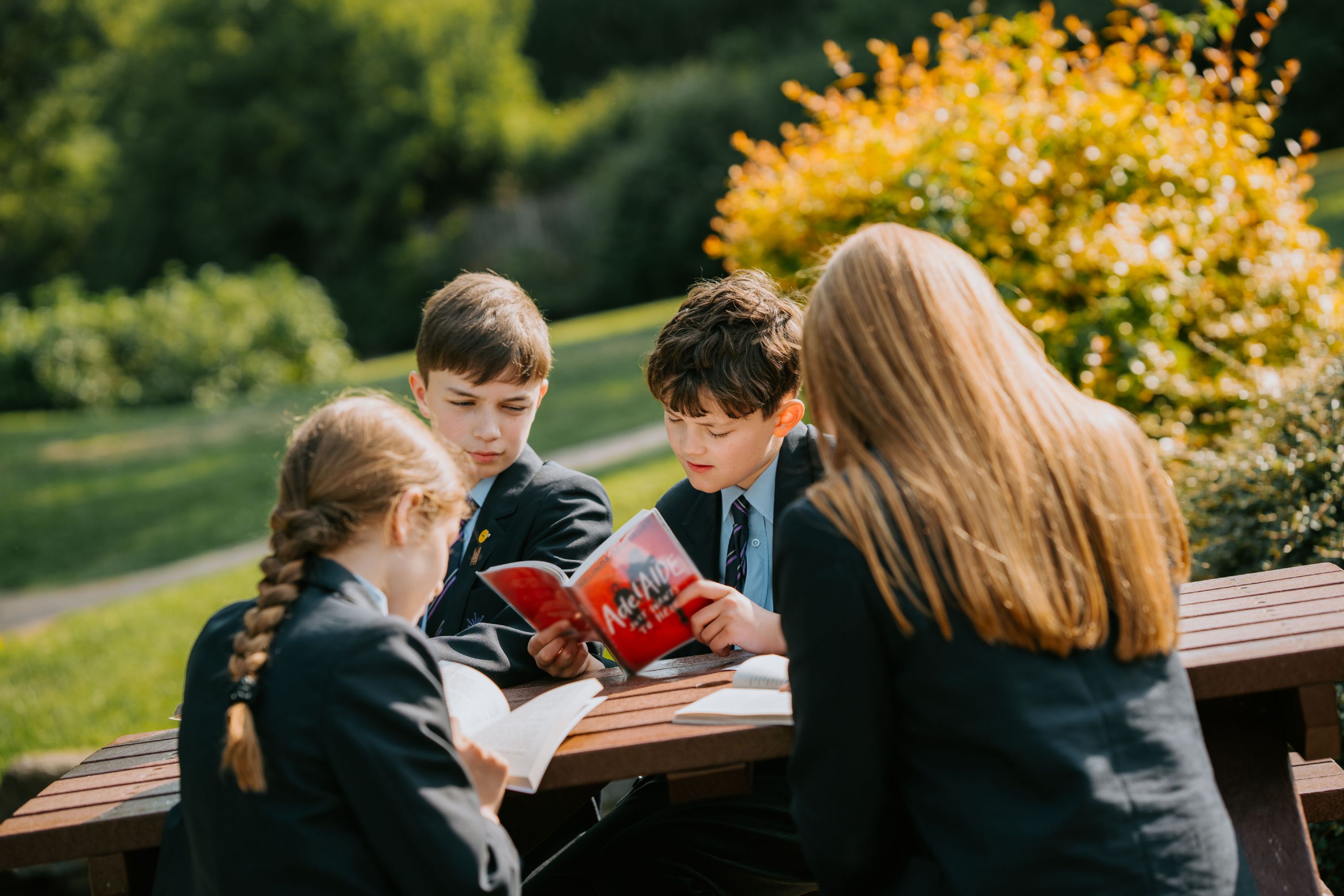 Priory students sat at a table reading together